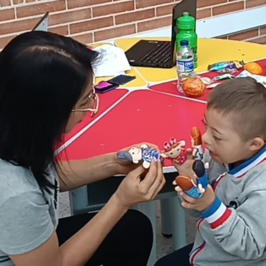 Maestra enseñando unos juguetes a un niño