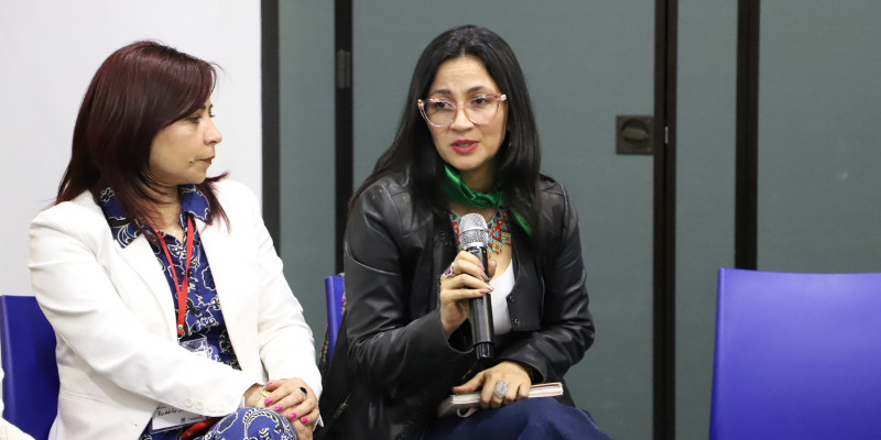 Foto de la profe Natalia Pinilla en un panel junto a otra profe