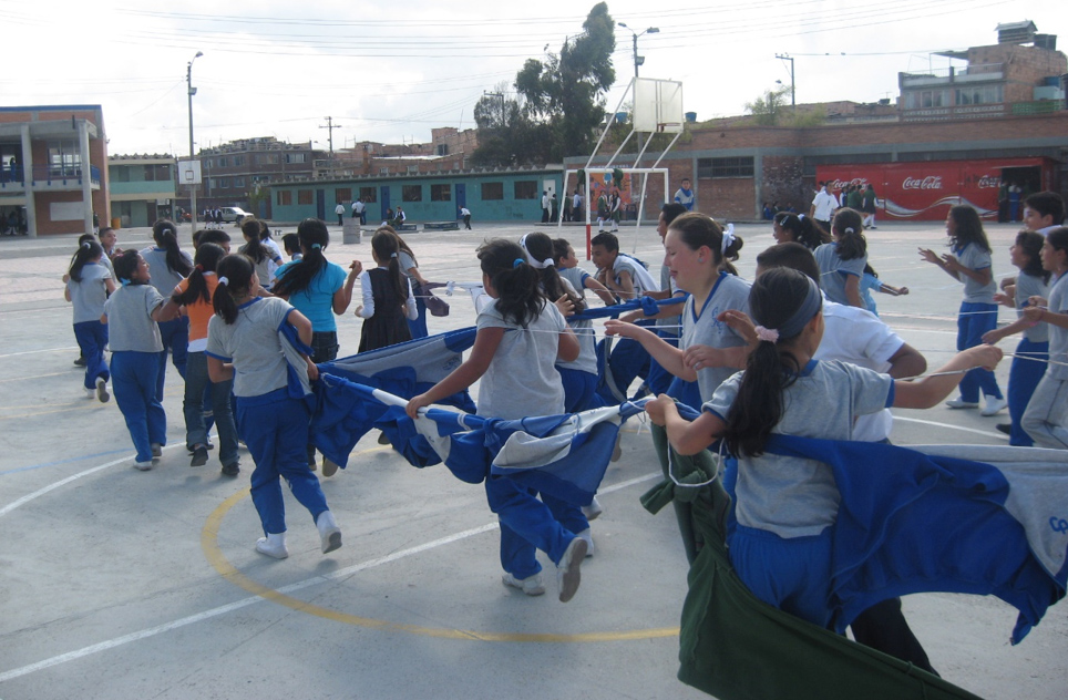 Estudiantes jugando con sacos del uniforme en el patio