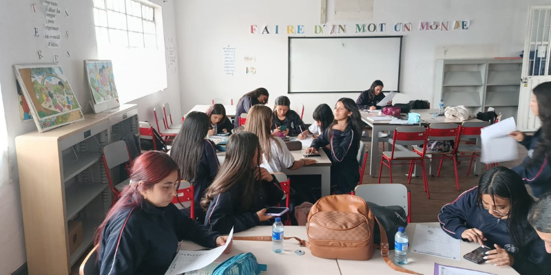 Foto de estudiantes organizados por grupos en el salón de clases