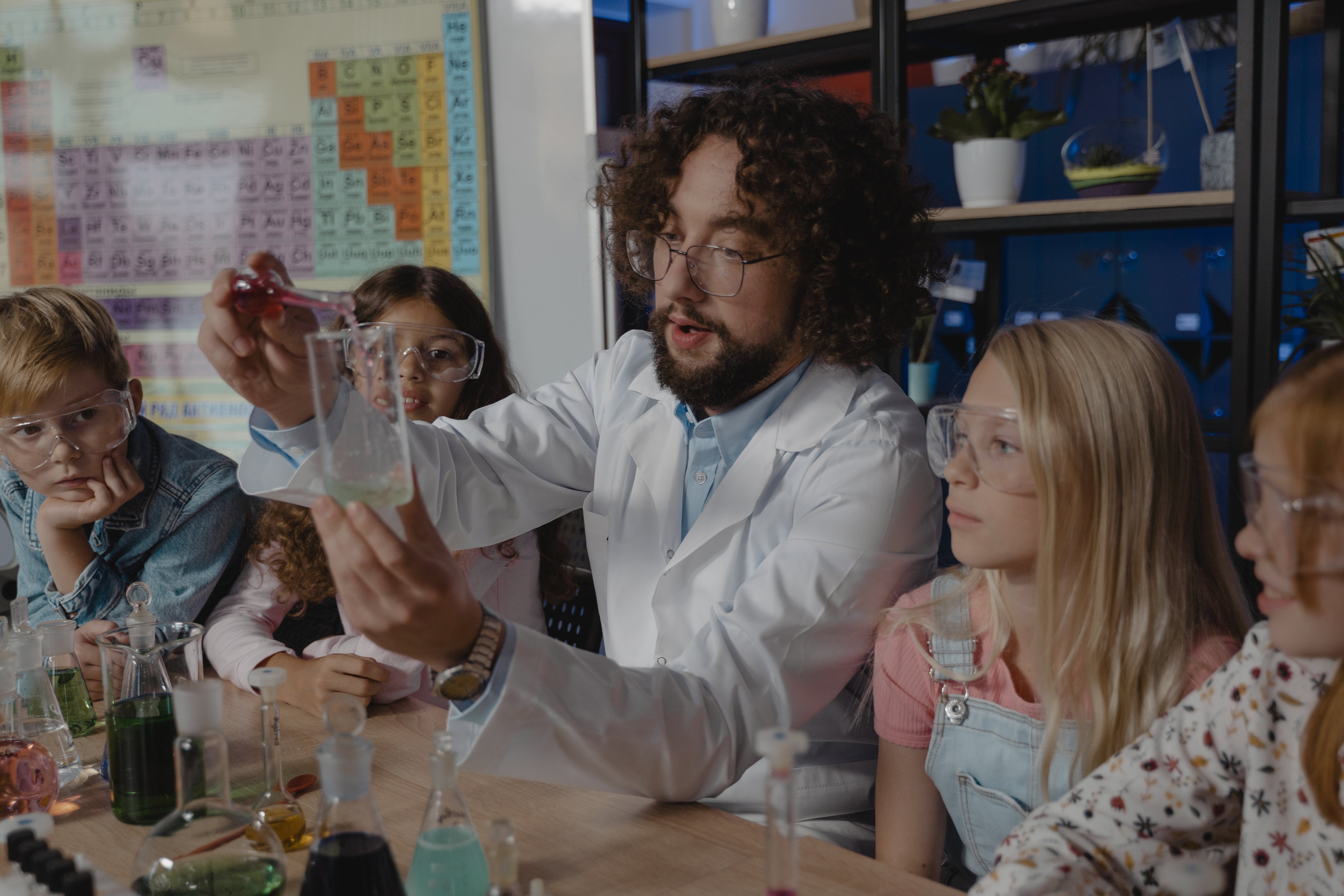 Un maestro con varios estudiantes haciendo practica de laboratorio